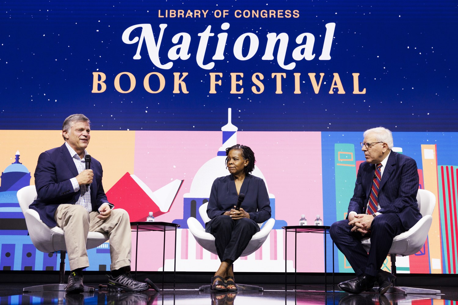 Three speakers seated onstage beneath National Book Festival signage.