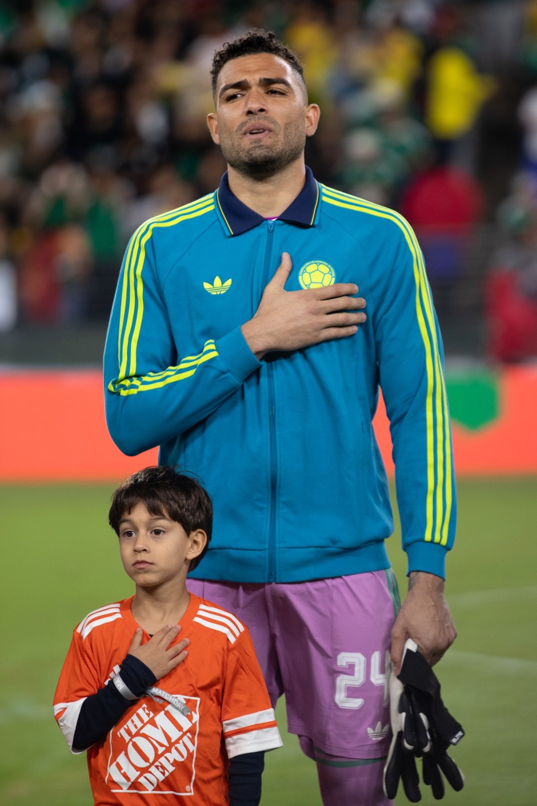 An anthem moment with a Colombia player and a child mascot.