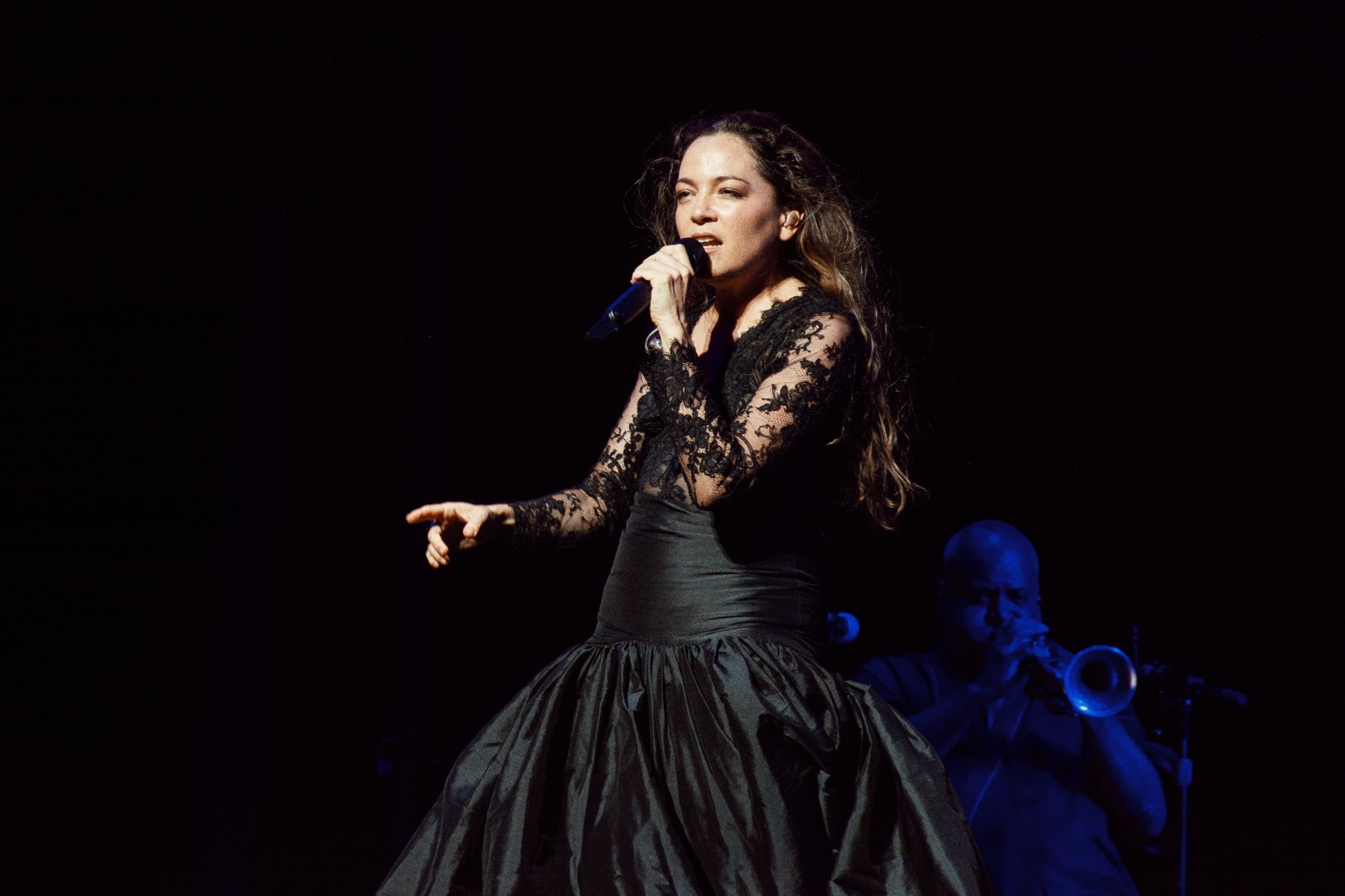 Natalia Lafourcade singing with musicians behind her.
